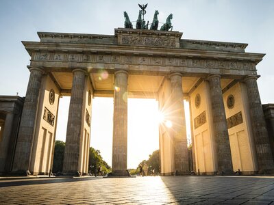 Brandenburg Gate: a large stone building with columns and statues on top with Brandenburg Gate in the background