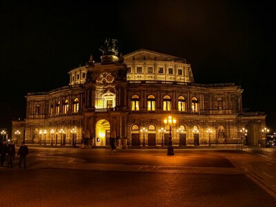 Semperoper Dresden: a large building lit up at night with people walking around