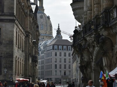 Fürstenzug: a group of people walking down a street next to tall buildings