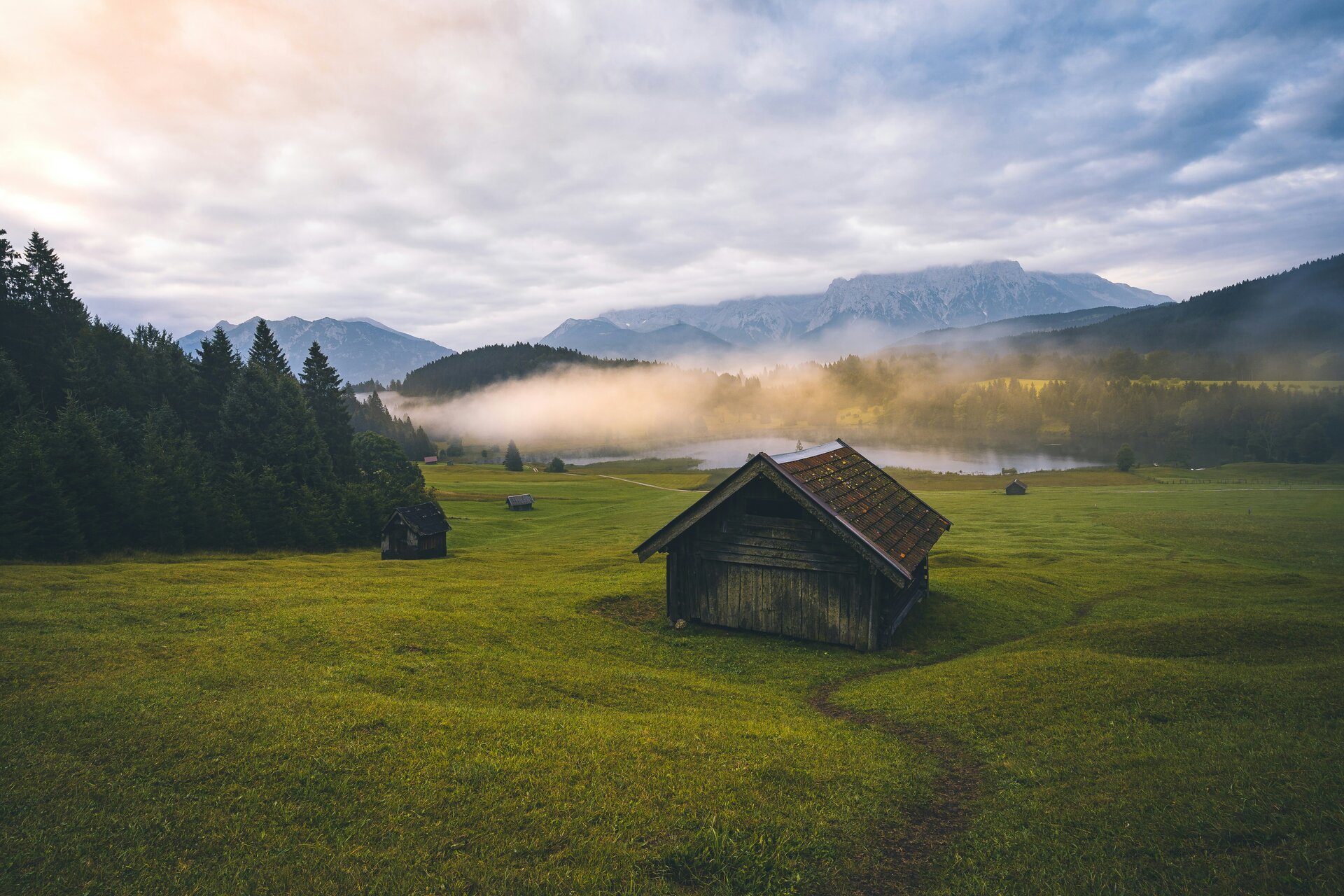 Fotospot Geroldsee: brown wooden house on green grass field near green trees and mountains during daytime