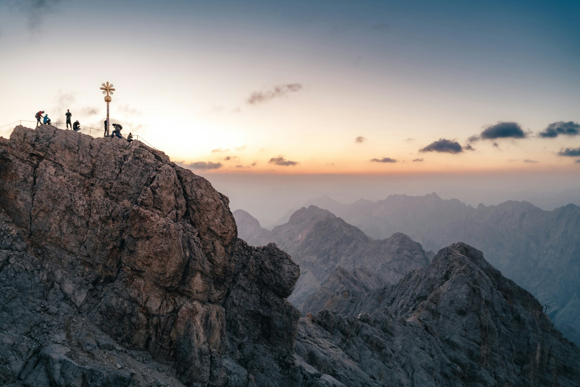 Fotospot Zugspitze: Hikers on a rocky mountain peak at sunset