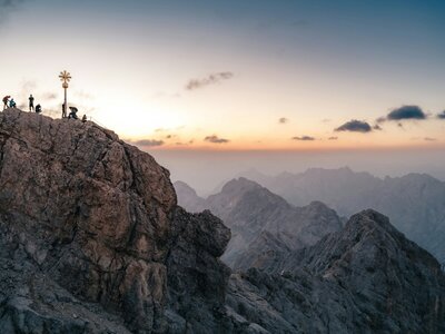 Zugspitze: Hikers on a rocky mountain peak at sunset