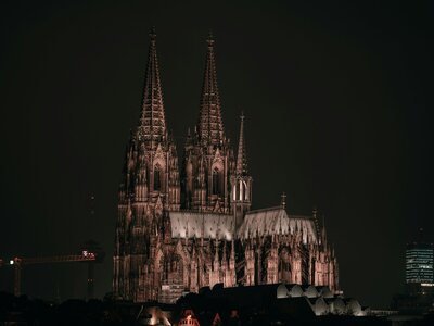 Kölner Dom: people walking near brown concrete building during night time