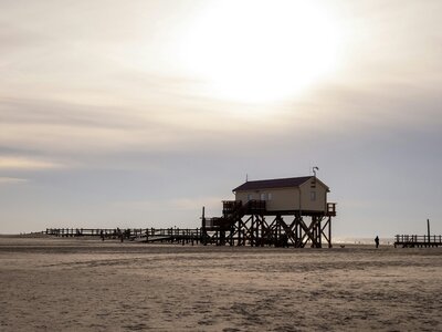 Pfahlbauten Sankt Peter Ording: a house on a beach with a pier in the background