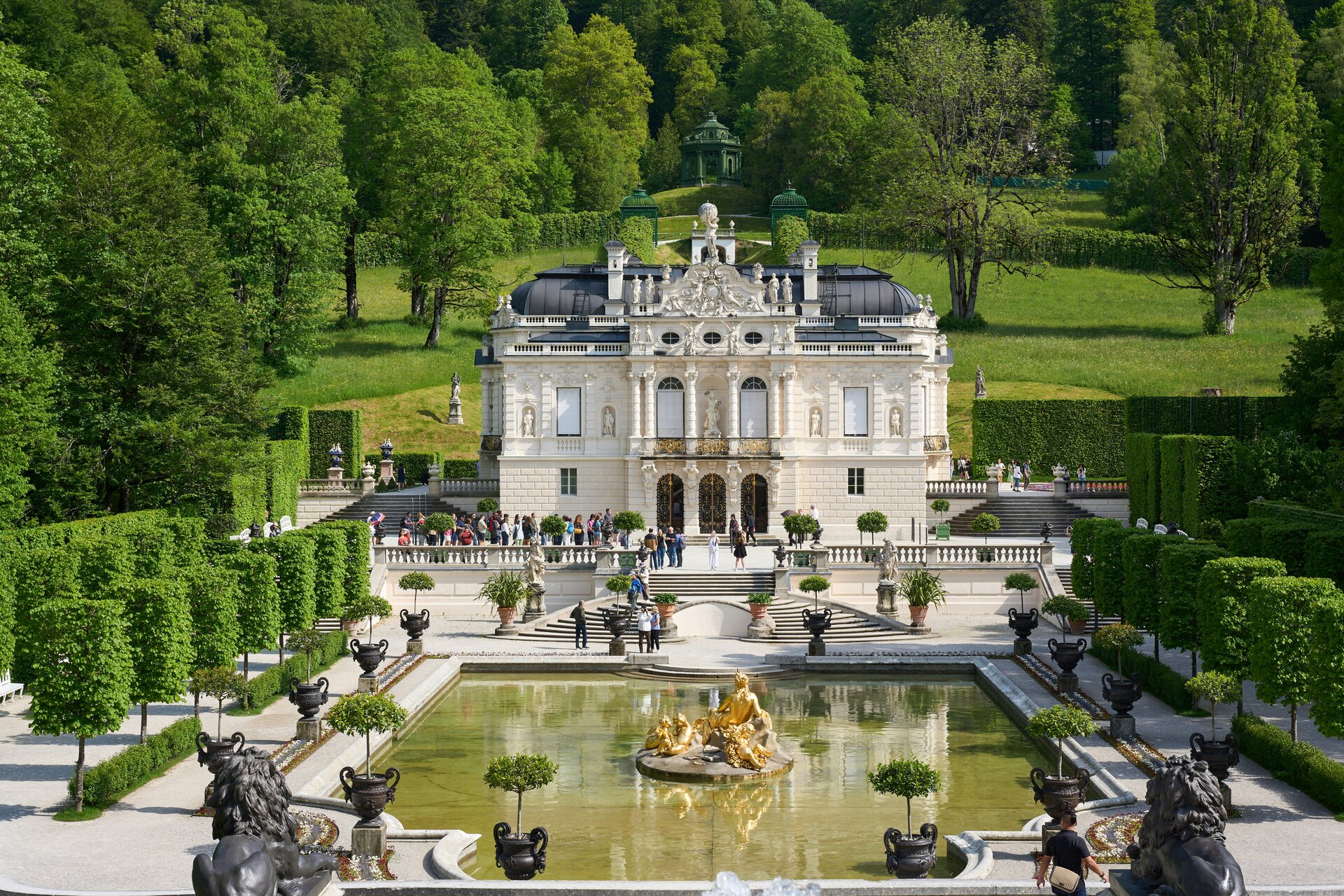 Fotospot Schloss Linderhof: a large building with a fountain in front of it