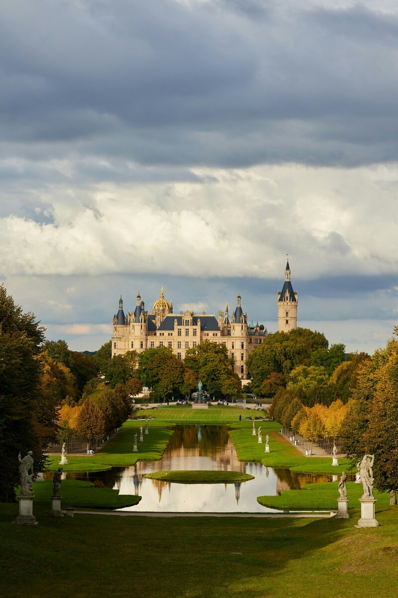 A large castle with a pond in its middle